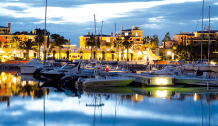 porto-degli-argonauti-barche-ormeggiate-di-sera-con-vista-sul-paese-illuminato